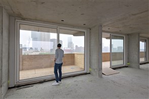 Kopers toekomstige eigenaars van Fenixlofts, een voormalige havenloods, en bezoekers bekijken de nieuwbouw appartementen in ruuwbouw fase op de dag van de bouw